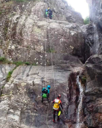 Personnes qui descendent en rappel dans un canyon.