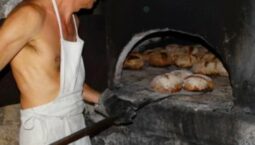 le boulanger sort les miches de pain du four.