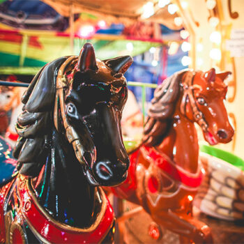 Carrousel à la fête foraine, zoom sur la tête d'un cheval appartenant au manège.