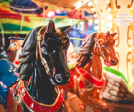 Carrousel à la fête foraine, zoom sur la tête d'un cheval appartenant au manège.