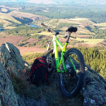 VTT posé contre les rochers face à la vallée.