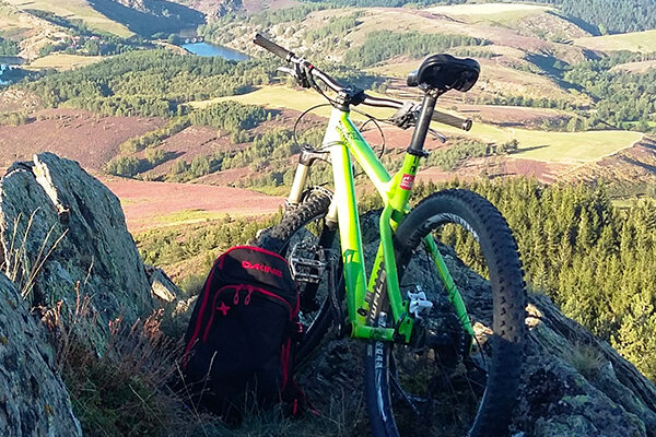 VTT posé contre les rochers face à la vallée.