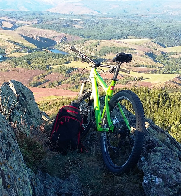 VTT posé contre les rochers face à la vallée.